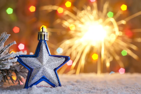 Christmas star on snow and blurred background with sparklers — Stock Photo, Image