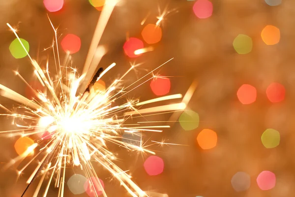 Sparkler and colorful bokeh christmas new year background — Stock Photo, Image