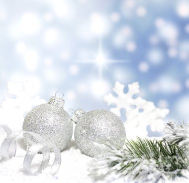 Noel ağacının dalını gümüş baubles şerit ve üzerinde mavi arka plan kar