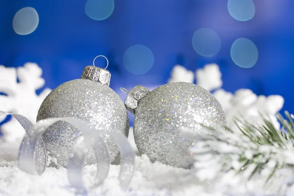 Ramo di Natale del nastro albero argento bagattelle e neve su sfondo blu — Foto Stock