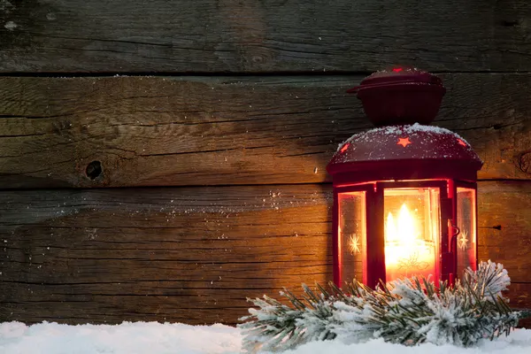 Lanterne de Noël lumière dans la nuit sur la neige et les planches en bois — Photo