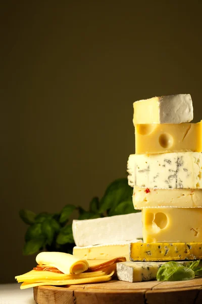 Pile of cheese many various types on cutting board — Stock Photo, Image