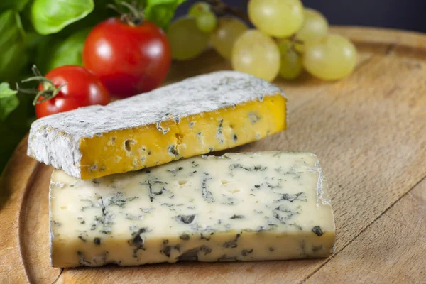 Käse auf Schneidebrett Nahaufnahme mit Basilikum — Stockfoto
