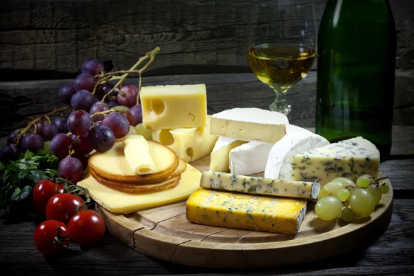 Cheese wine and grapes various assortment vintage still life — Stock Photo, Image