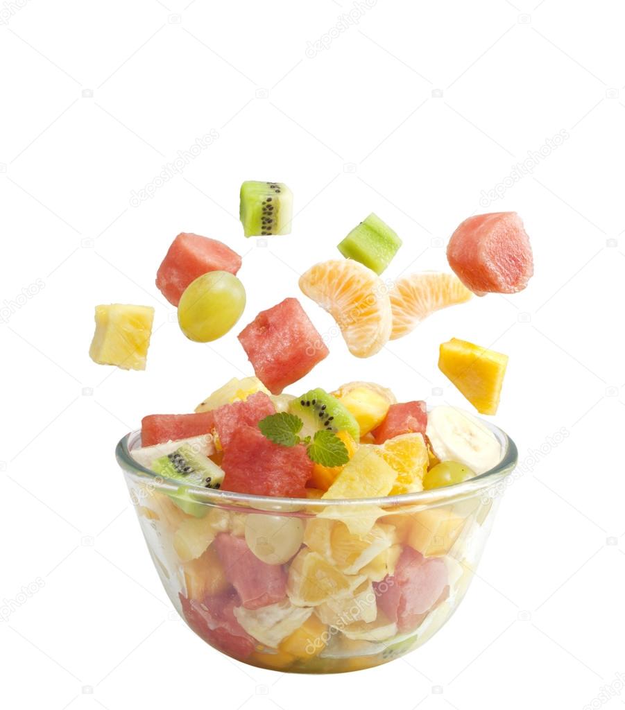 Fruits salad flies to the bowl isolated on white background