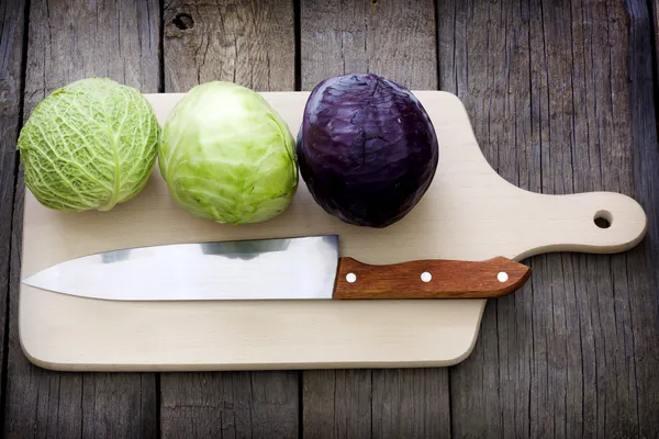 Repolho e faca na preparação da placa de corte para cozinhar — Fotografia de Stock