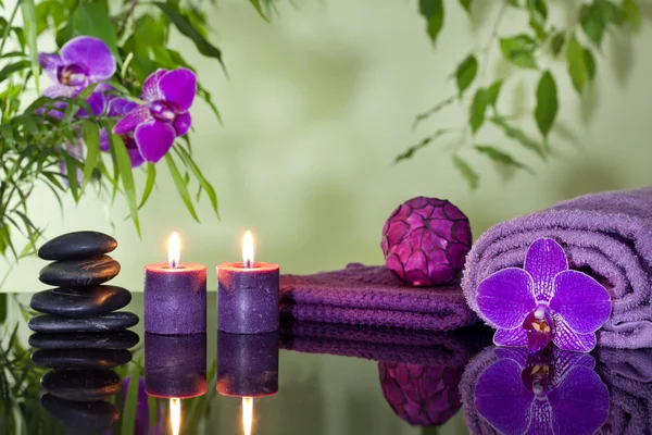 Zen stenar orkidé aromatiska ljus och handduk spa koncept — Stockfoto