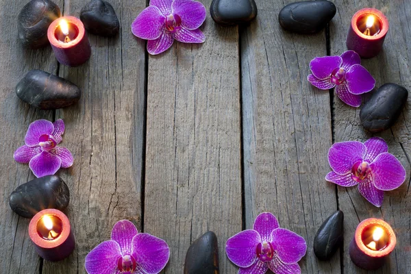 Orquídeas e pedras spa fronteira fundo em tábuas de madeira — Fotografia de Stock