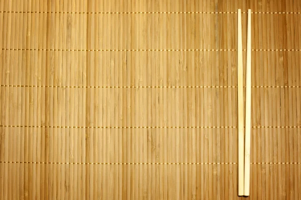 Bamboe mat en eetstokjes voedsel achtergrond — Stockfoto