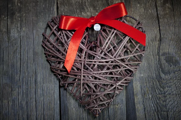 Wicker heart on wooden boards valentines concept — Stock Photo, Image