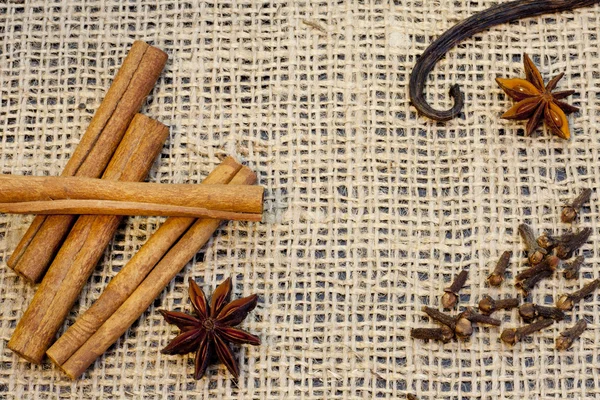 Aroma spices cinnamon anise vanilla and cloves on jute — Stock Photo, Image