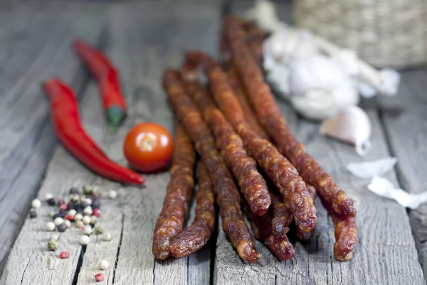 Sausage and spices on vintage wooden boards closeup — Stock Photo, Image