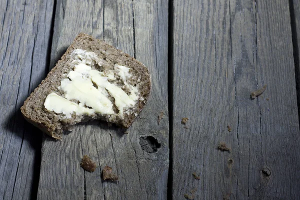 Brotscheibe auf alten Holzbrettern — Stockfoto