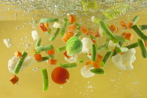 Vegetais salpicam em conceito de cozinha sopa de água — Fotografia de Stock