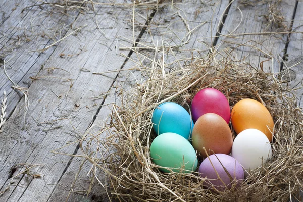 Uova di Pasqua in nido su tavole di legno vintage sfondo — Foto Stock