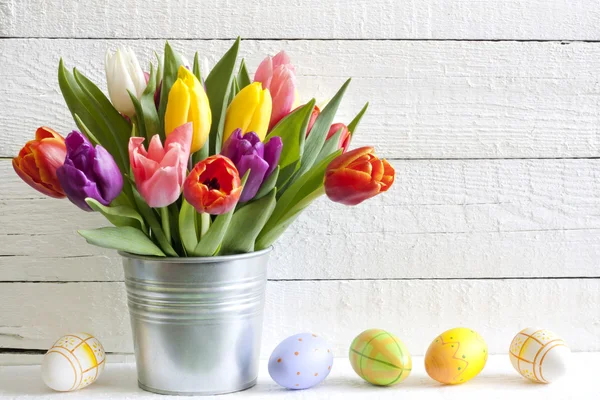 Tulipas de Páscoa de primavera em balde em pranchas vintage brancas — Fotografia de Stock