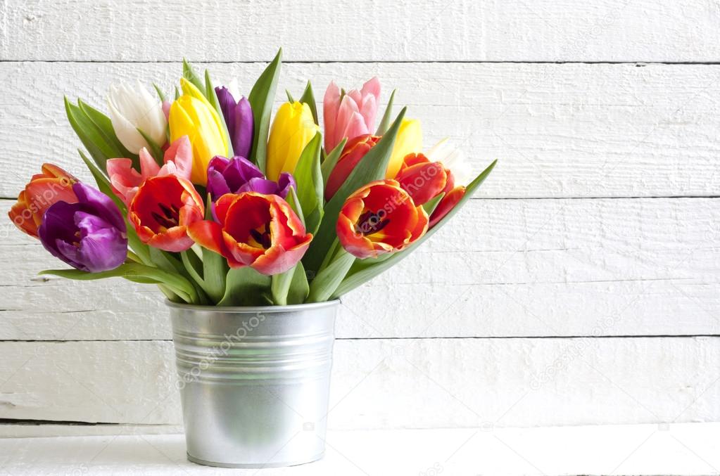 Spring easter tulips in bucket on white vintage planks