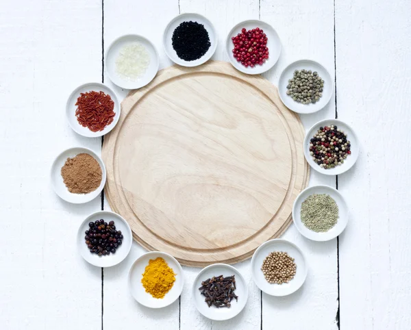 Spices and dried vegetables with cutting board on white planks — Stock Photo, Image