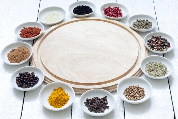 Especias y verduras secas con tabla de cortar sobre tablones blancos — Foto de Stock