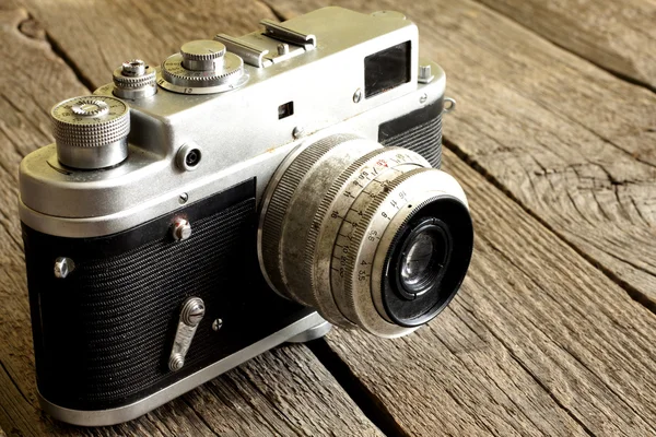 Old retro camera on vintage wooden boards abstract background — Stock Photo, Image