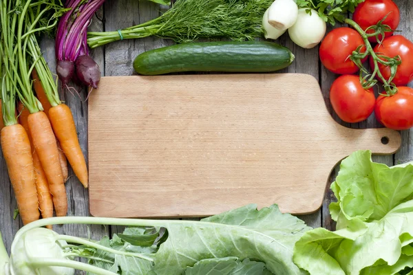 Muchas verduras orgánicas frescas y fondo de tabla de cortar vacío — Foto de Stock