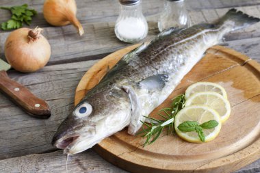 Mutfaktaki baharatlar ile kesme tahtası üzerinde morina çiğ balık