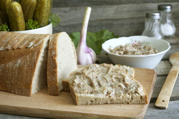 Bröd ister och pickles på gamla vintage cutting board stilleben — Stockfoto