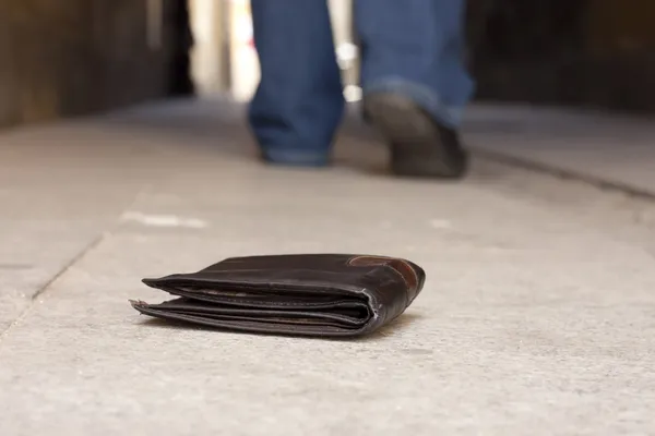 Cartera perdida en la calle y las piernas del hombre caminante concepto — Foto de Stock