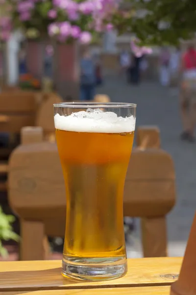 Verre de bière au restaurant sur la table en plein air au soleil — Photo