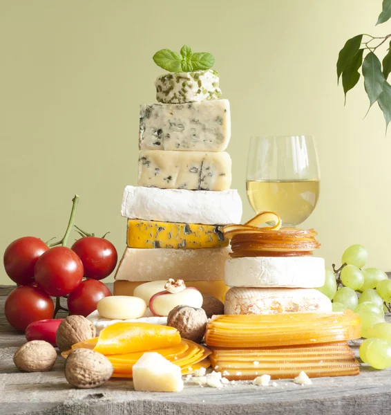 Montón de quesos muchos tipos diferentes con uvas de vino y nueces — Foto de Stock