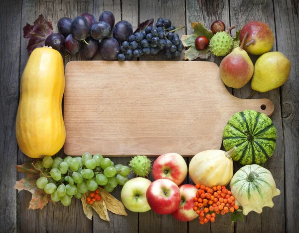 Frutas e produtos hortícolas do Outono e tábua de corte vazia — Fotografia de Stock