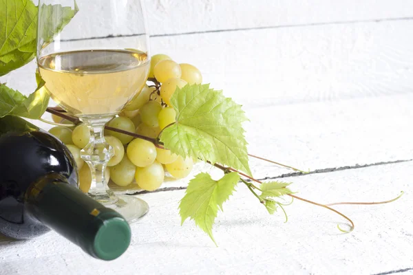 Beyaz şarap şişesi ve üzüm vintage kurulları ile — Stok fotoğraf