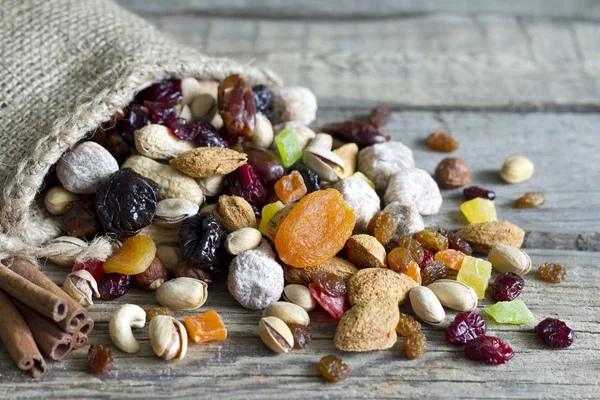 Nüsse und Trockenfrüchte auf alten Holzbrettern Stillleben — Stockfoto