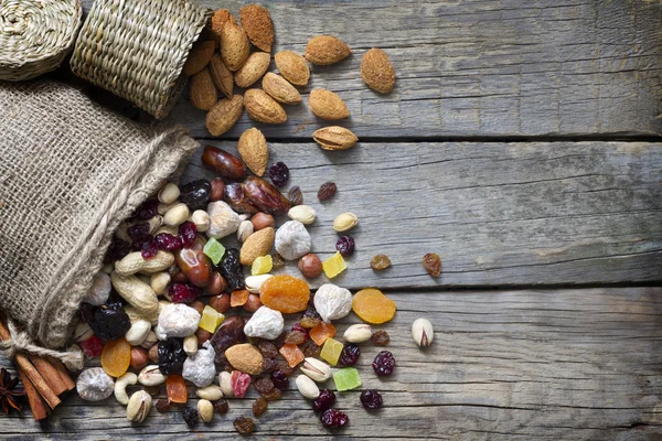 Nüsse und Trockenfrüchte auf alten Holzbrettern Stillleben — Stockfoto