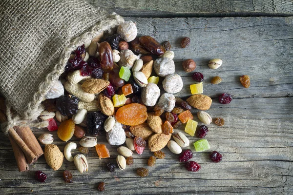 Nüsse und Trockenfrüchte auf alten Holzbrettern Stillleben — Stockfoto