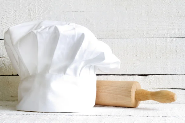 Chapéu Chef e utensílios de cozinha de madeira comida abstrata em placas brancas — Fotografia de Stock