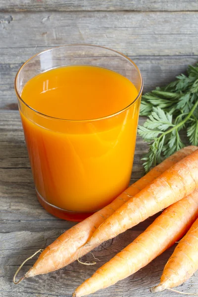 Органический морковный сок на деревянных досках — стоковое фото