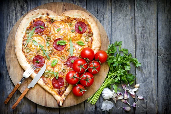 Pizza a forma di cuore con formaggio e pomodoro su taglieri vintage — Foto Stock