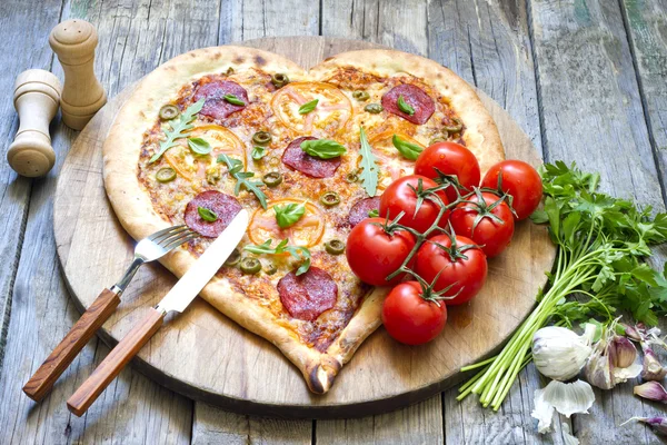 Tvar srdce pizza se sýrem a rajčaty na vinobraní desek — Stock fotografie