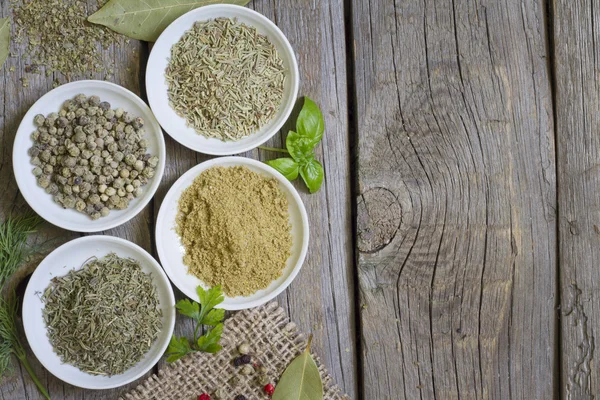 Herbs and dried spices on wooden board — Stock Photo, Image