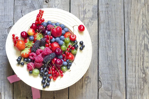 Frutti di bosco estivi nel concetto di cappello su tavole vintage — Foto Stock