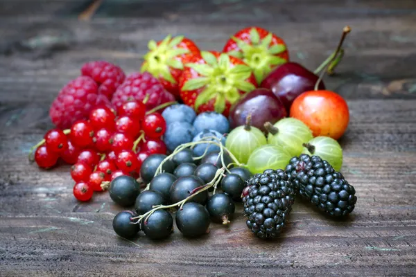 Summer wild berry fruit on vintage board still life concept — Stok Gambar Summer wild berry fruit on vintage board still life concept Stok Foto Bebas Royalti