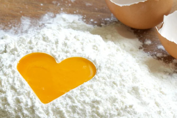 Yolk egg in flour love baking concept — Stock Photo, Image