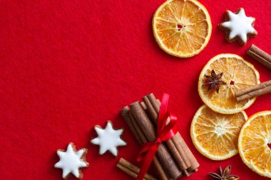 Kurumuş portakal, tarçın ve kurabiyeli Noel kırmızı arka planı