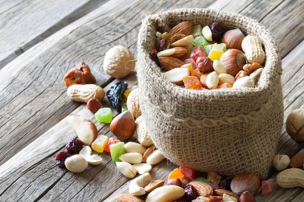 Blandning Torkad Frukt Och Nötter Jutesäck Trä Bakgrund — Stockfoto