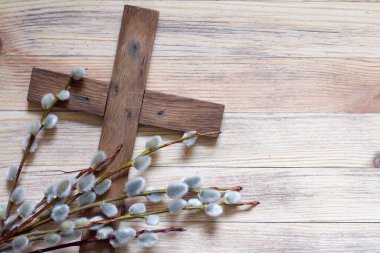 Easter cross with catkins on wooden background, palm sunday religious concept abstract clipart