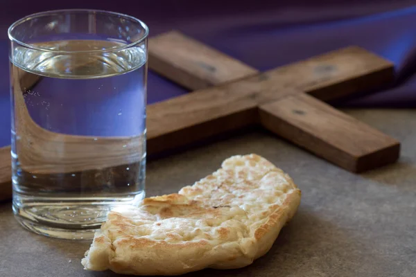Fastenzeit Konzept Wasser Brot Und Kreuz Auf Violettem Stoff — Stockfoto