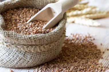 Tahta arka planda, kenevir çuvalında karabuğday