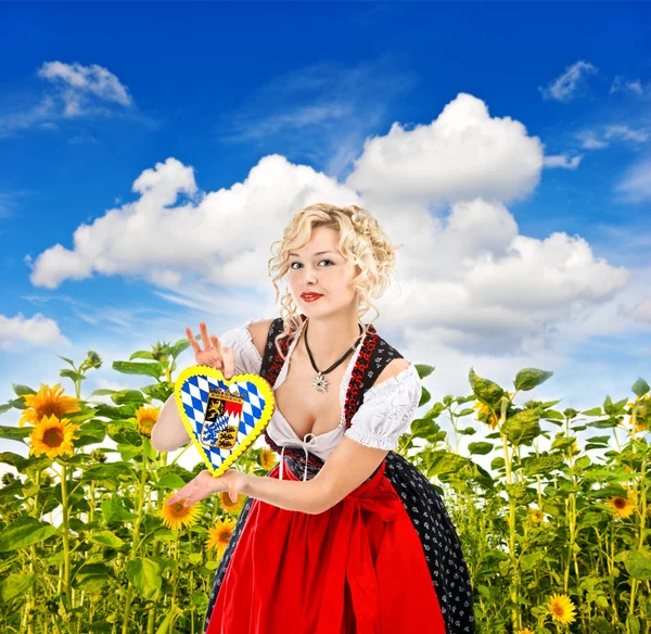 Menina bávara em vestido de tracht dirndl no campo de girassol — Fotografia de Stock