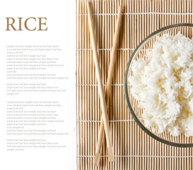 bowl of white steamed rice with chopsticks on bamboo mat